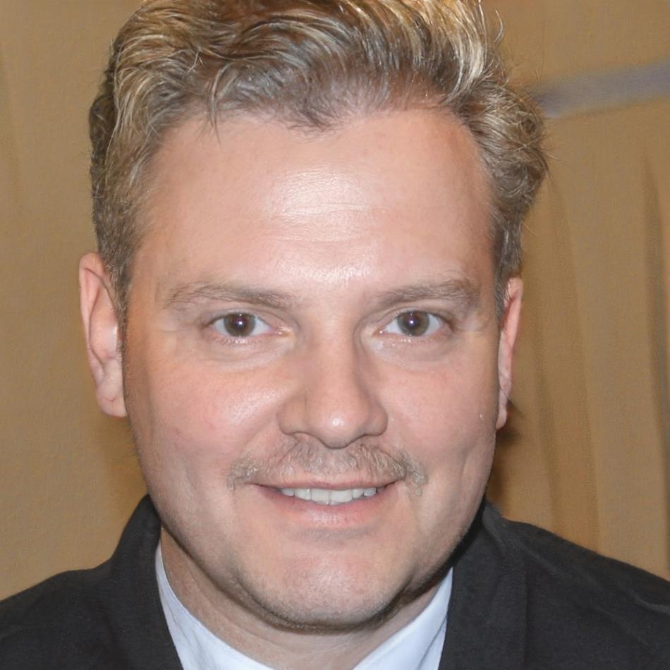 Miguel Torres, coordinador de programas de Tronelio Camerva, sonriendo en un ambiente profesional y acogedor